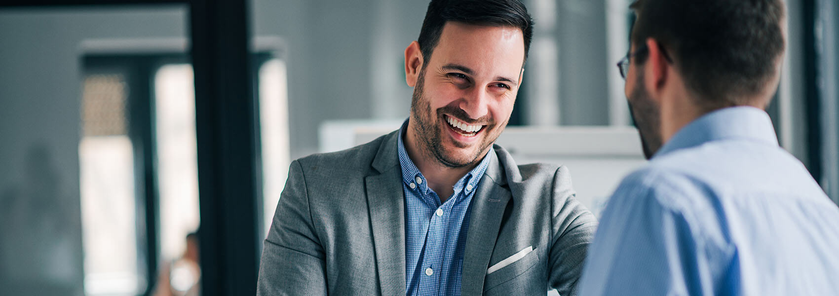 man smiling as he meets another person